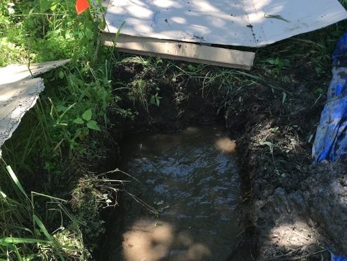 A flooded soil pit, which indicates a wetland.