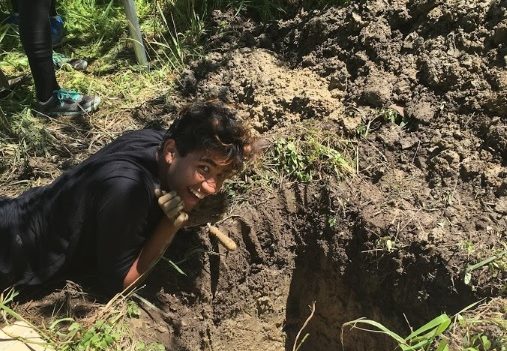 Undergraduate intern Kunal Palawat poses by a soil pit.